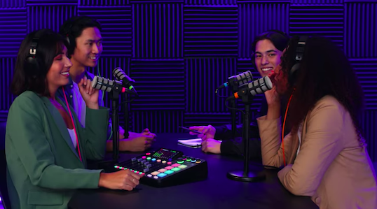 Grupo de cuatro personas grabando un podcast con RØDECaster Pro II y micrófonos RØDE