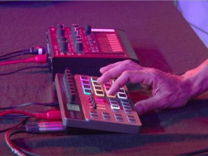 Músico utilizando la groovebox Donner Essential D1 en directo junto a otro equipo