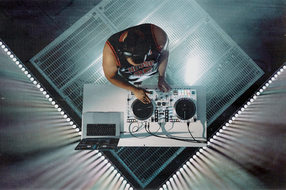 DJ utilizando la RANE ONE MKII en cabina con portátil y controladora motorizada