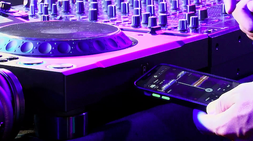 Mano acercando un smartphone al lector NFC del CDJ-3000X de AlphaTheta